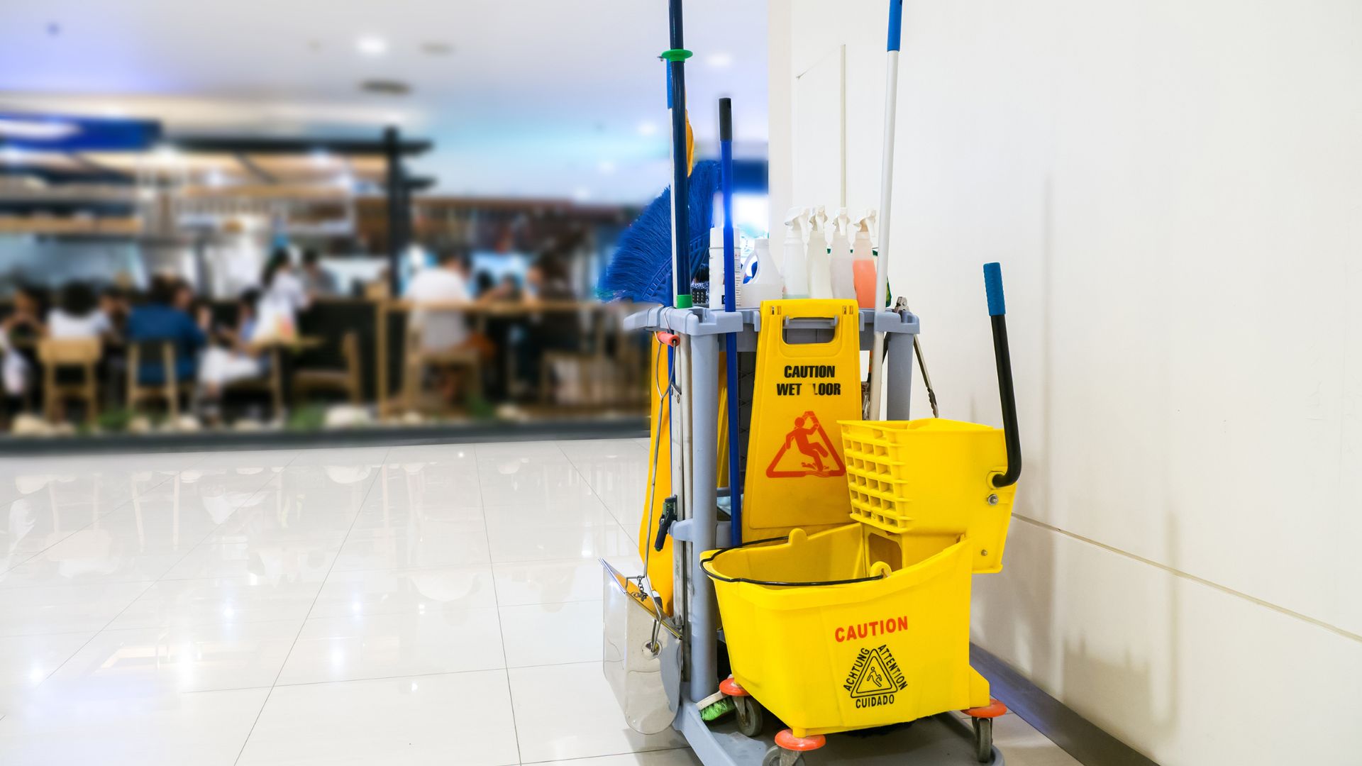 A yellow cleaning machine sitting on top of a tiled floor